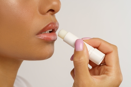 mixed-race-female-applying-hygienical-chapstick-lip balm, lip stick, chapped lip