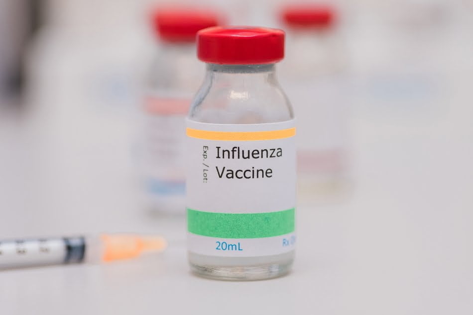 Flu vaccine concept, influenza vaccine vial sitting on a desk