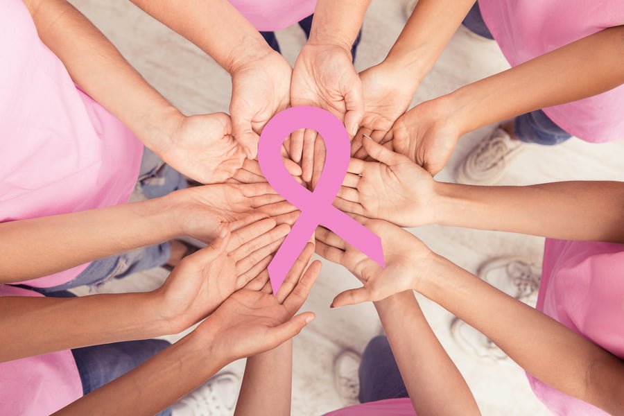 Circle Of Diverse Women Hands Holding Pink Breast Cancer Ribbon Standing Together Indoor. Oncology And Support. Top View