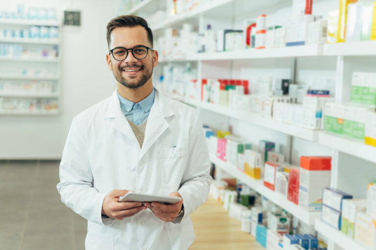 Portrait of a handsome pharmacist working in a pharmacy. Pharmacy intern in a pharmacy