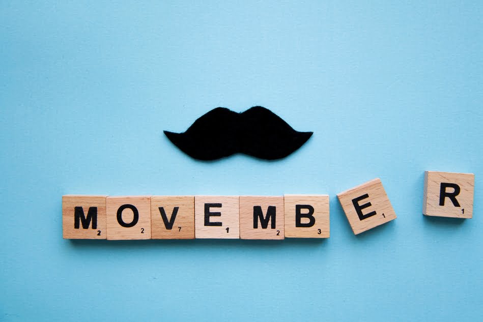 Movember letters on the blue background with black moustache. Preventing prostate cancer awareness month.
