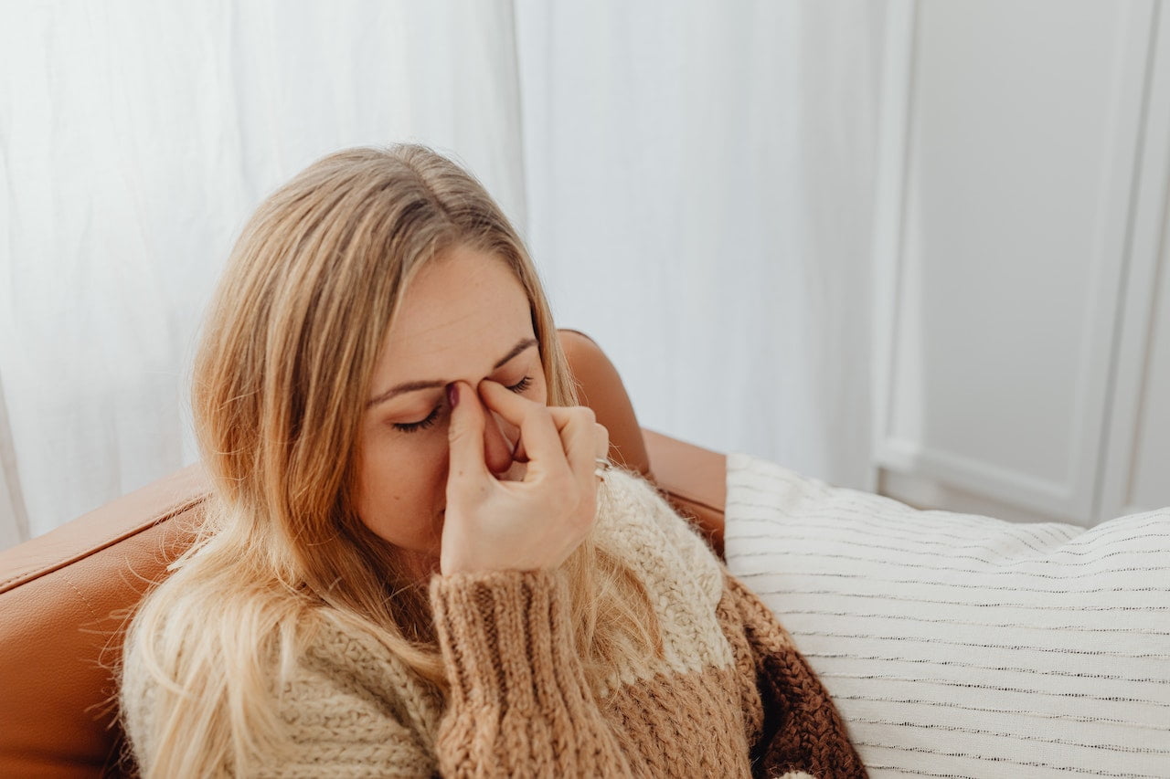 Woman Holding Her Nose Because of Sinus Pain. Woman suffer from sinus infection (sinusitis).