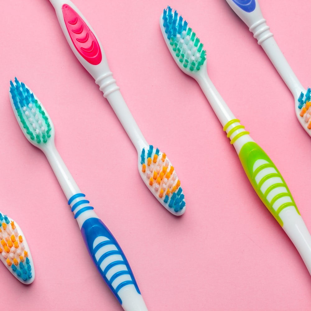 Toothbrushes on pink background. Change Your Toothbrush concept.