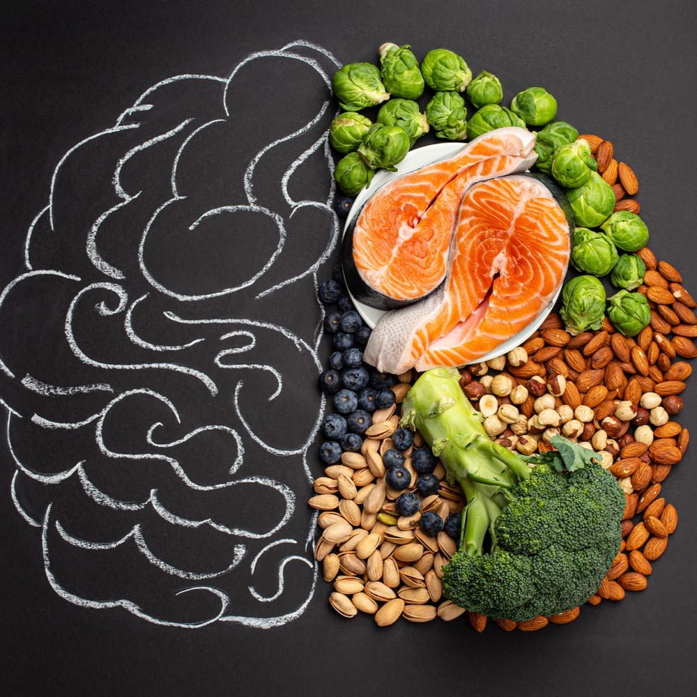 Chalk hand drawn brain picture with assorted food, food for brain health and good memory: fresh salmon, vegetables, nuts, berries on black background. Foods to boost brain power, top view. Gut-brain connection concept.