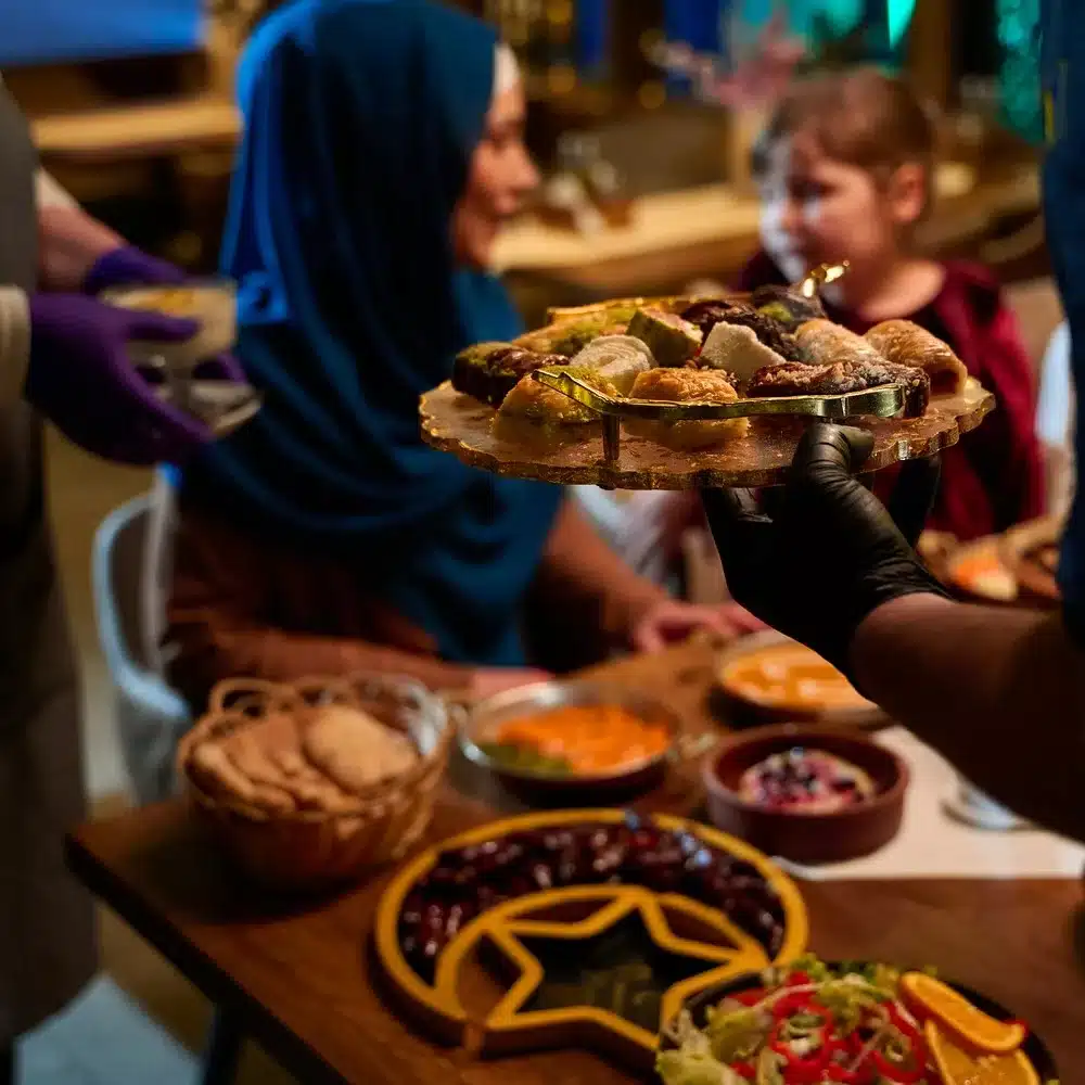 In a heartwarming scene, a professional chef serves a European Muslim family their Iftar meal during the holy month of Ramadan, embodying cultural unity and culinary hospitality in a moment of shared celebration and gratitude. Digestive problems during Ramadan concept.