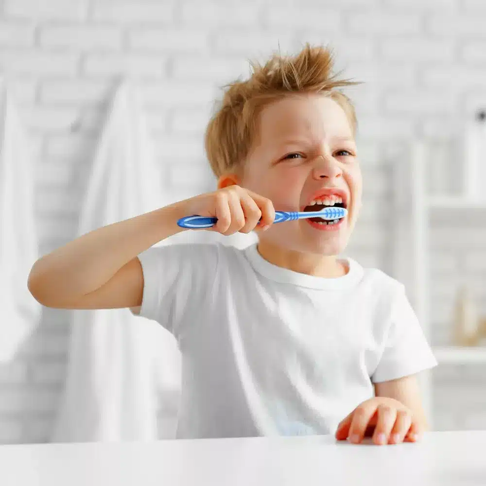 Little boy brushing his teeth diligently in bathroom. Kids’ teeth care. Dental care. Kid’s teeth