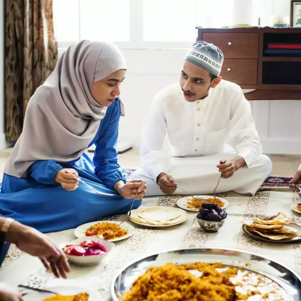 Muslim family having dinner on the floor. digestive aids for Eid Al-Adha